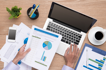 Financial concept. business earning report and financial chart and graph report on desk.の写真素材