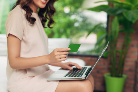 Beautiful asian woman holding a credit card and purchasing onlineの写真素材