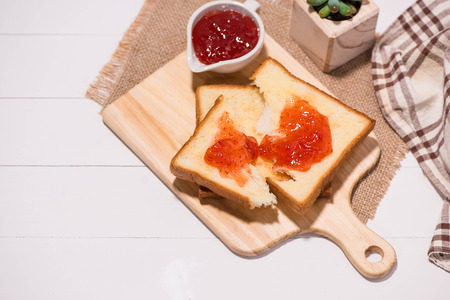 Toast with strawberry jam on a plate on table.の写真素材