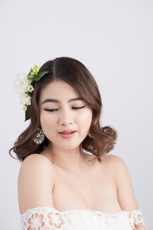 Beautiful asian woman bride on grey background. Closeup portraits with a professional makeupの写真素材