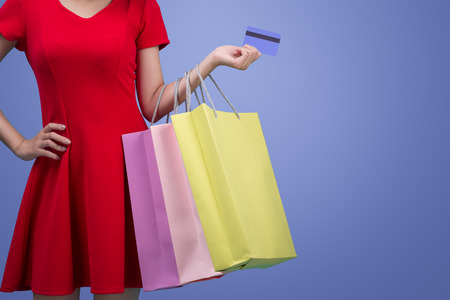Asian girl showing credit card in hand, over violet backgroundの写真素材