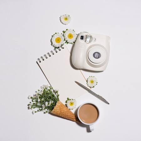 Creative flat lay morning coffee and flowers with notebookの写真素材