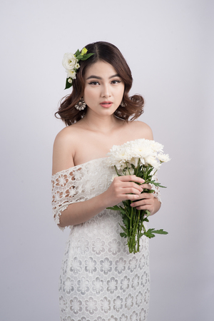 Beautiful asian woman bride on grey background. Closeup portraits with a professional makeupの写真素材