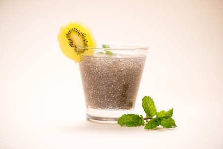 Selective focus of chia seeds drink with water in transparent glass with lemon balm.の写真素材