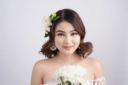 Beautiful asian woman bride on grey background. Closeup portraits with a professional makeupの写真素材