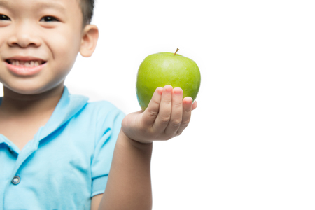Asian baby boy holding and eating red apple, isolated on whiteの写真素材