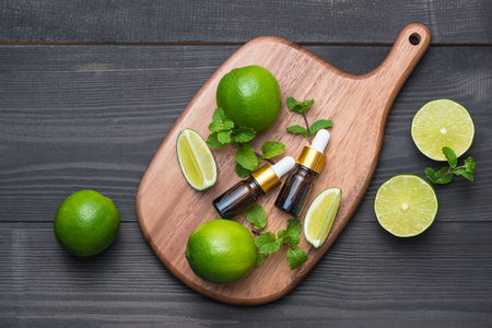 Natural cosmetics for home spa. Bottle of essence oil with fresh limesの写真素材