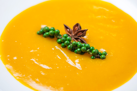 Pumpkin and carrot soup with cream and parsley on blue  wooden background.の写真素材