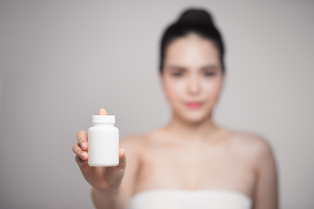 Healthy happy asian woman with pills bottle in hand.の写真素材