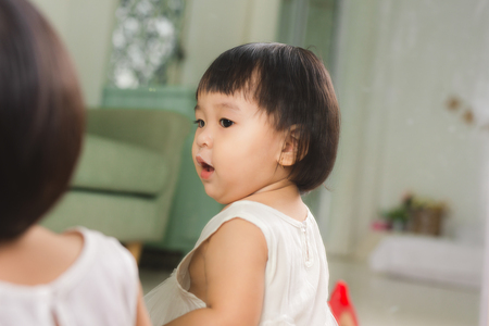 Little cute asian baby girl sitting on floors playingの写真素材