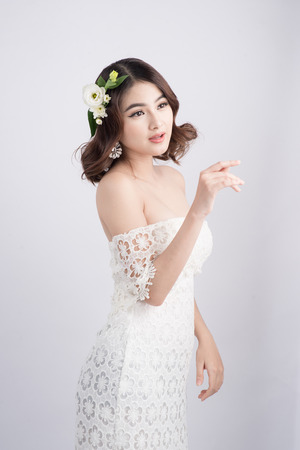 Beautiful asian woman bride on grey background. Closeup portraits with a professional makeupの写真素材