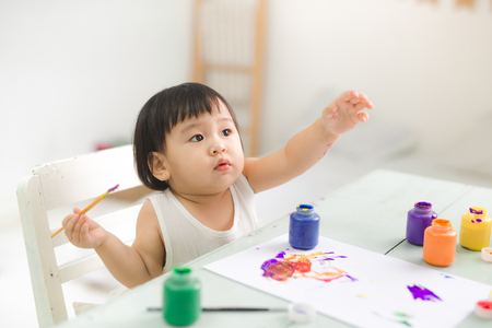 Happy family mother and daughter together paint. Asian woman helps her child girl.の写真素材