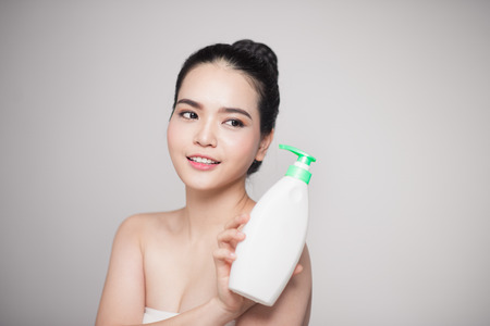 Shower gel. Joyful young woman advertising care product.の写真素材