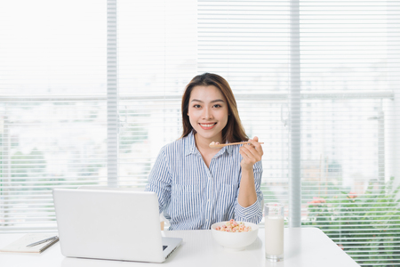 Female business executive eating lunch  at her workplaceの写真素材
