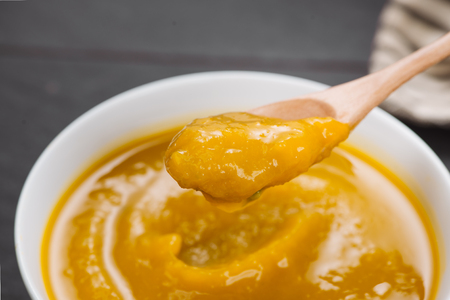 Spoon of homemade pumpkin soup on blank stone background.の写真素材