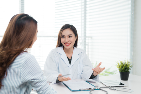 Smiling patient in the doctor's office, she is receiving a prescription medicineの写真素材