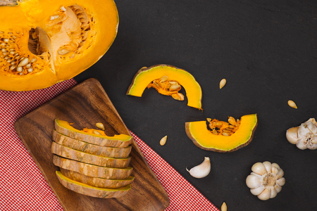 Delicious fresh pieces of ripe pumpkin on wooden backgroundの写真素材