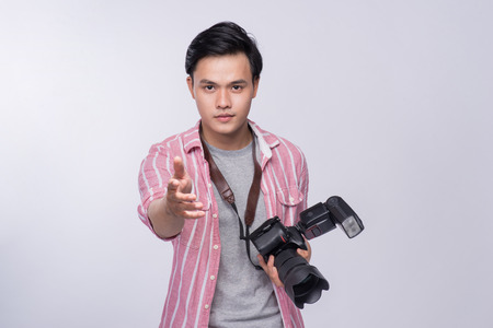 Young asian photographer holding digital camera, while working in studioの写真素材