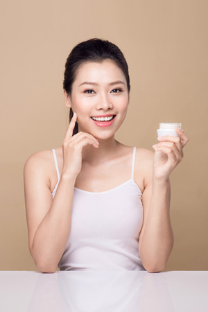 Skincare. Beautiful asian woman show moisturizer or lotion product.の写真素材