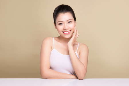 Beauty face. Facial treatment. Young asian woman with clean perfect skin touch her face.の写真素材