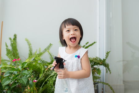 Child taking care of plants. Cute little girl watering first spring flowersの写真素材