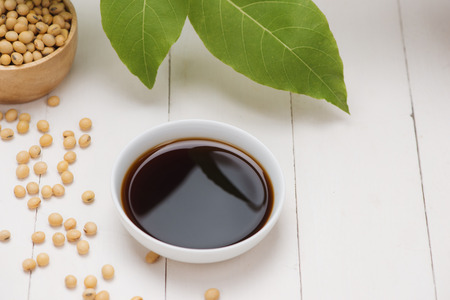 Soy sauce and soy bean on wooden tableの写真素材