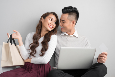 Couple shopping online. Happy couple looking together sitting floor at homeの写真素材