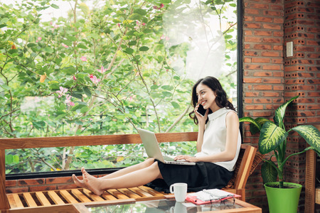 Confident young asian woman in smart casual wear talk on phone.の写真素材
