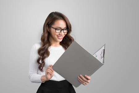 Portrait of young confident asian business woman with folderの写真素材