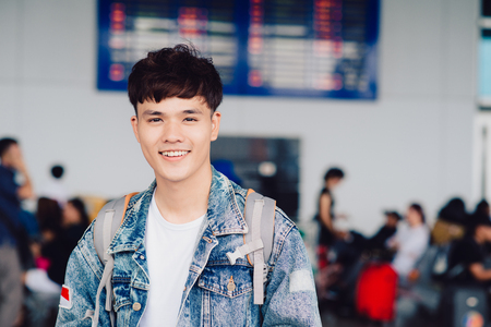 Portrait of smiling man with backpack in airportの写真素材
