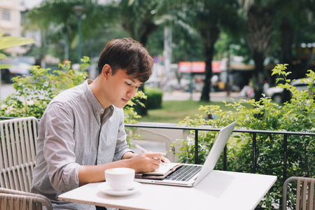 Young male freelancer working with laptop computer in comfortable coffee shopの写真素材