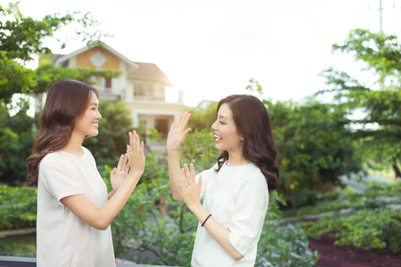 Happy young women friends well-dressed smiling while standing togetherの写真素材