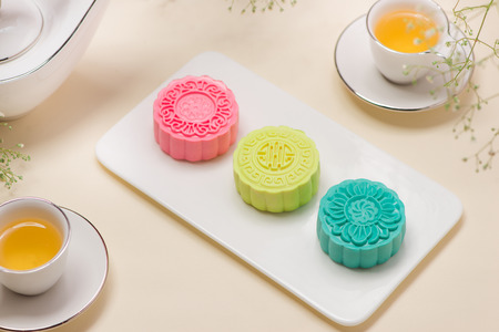 Colorful snow skin mooncake with tea pot on pink backgroundの写真素材