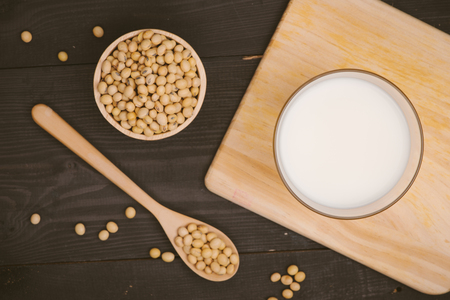 Glass with soy milk and soy bean on wooden backgroundの写真素材