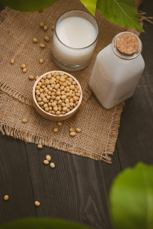 Bottle of soy milk and soybean on wooden tableの写真素材