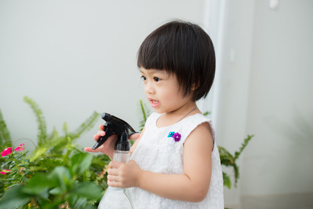 Child taking care of plants. Cute little girl watering first spring flowersの写真素材