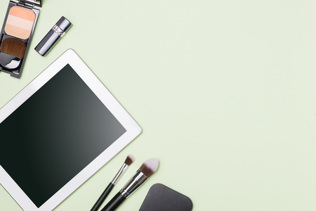 Flat lay of make up cosmetic products with digital tablet on light color backgroundの写真素材