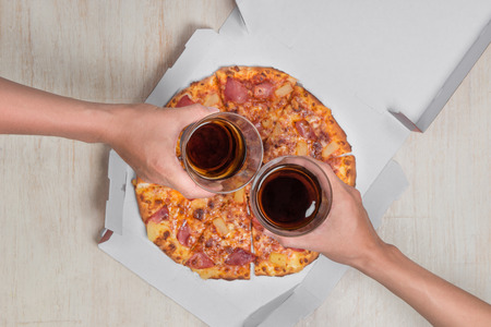 Happy people sitting around the table eating lunch at coworking office during breakの写真素材