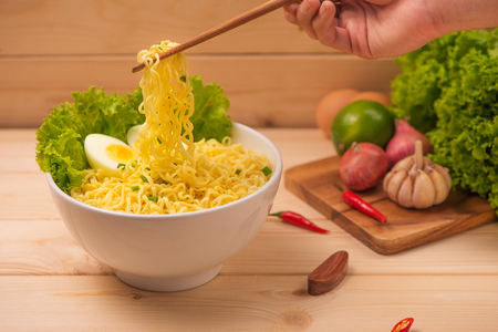 Eating Instant noodles with a wooden chopstick.の写真素材