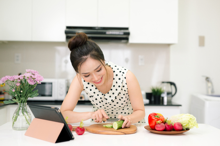 Portrait of young asian beautiful woman cooking in kitchenの写真素材