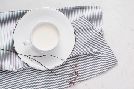 Creative flat lay, morning milk and white flower on white background. View from above.の写真素材