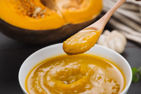 Spoon of homemade pumpkin soup on blank stone background.の写真素材