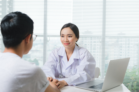 Doctor woman and male patient are discussingの写真素材