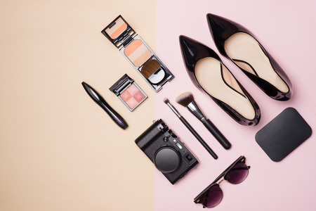 A collection of make up cosmetic beauty with camera and shoes on light color backgroundの写真素材
