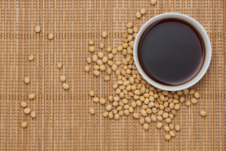 Soy sauce and soy bean on wooden tableの写真素材