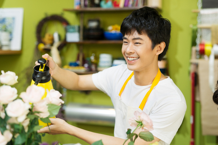 Male florist with beautiful bouquets in flower shop.の写真素材