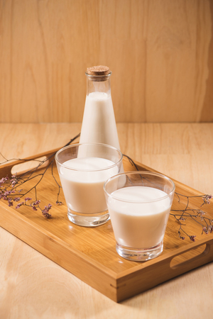 Milk bottle and milk glass on wooden table. Healthy eating conceptの写真素材