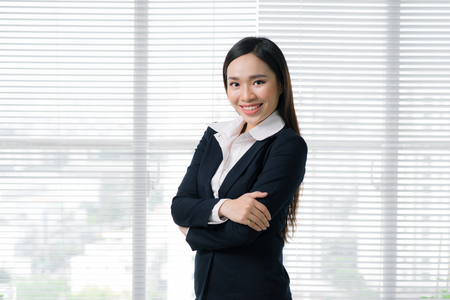Confident asian businesswoman standing in modern officeの写真素材