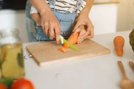 Mother with her daughter preparing lunch in the kitchen and enjoying together.の写真素材