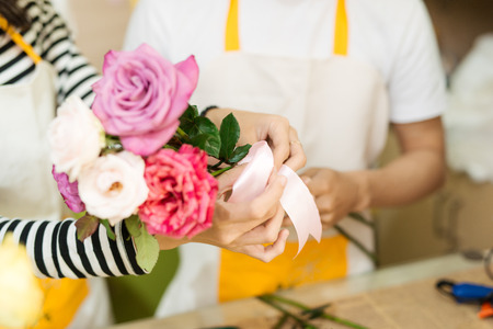 Male and female florists with beautiful bouquets in flower shop.の写真素材